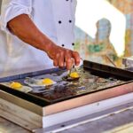 Image of cook preparing fresh eggs for a breakfast offer.